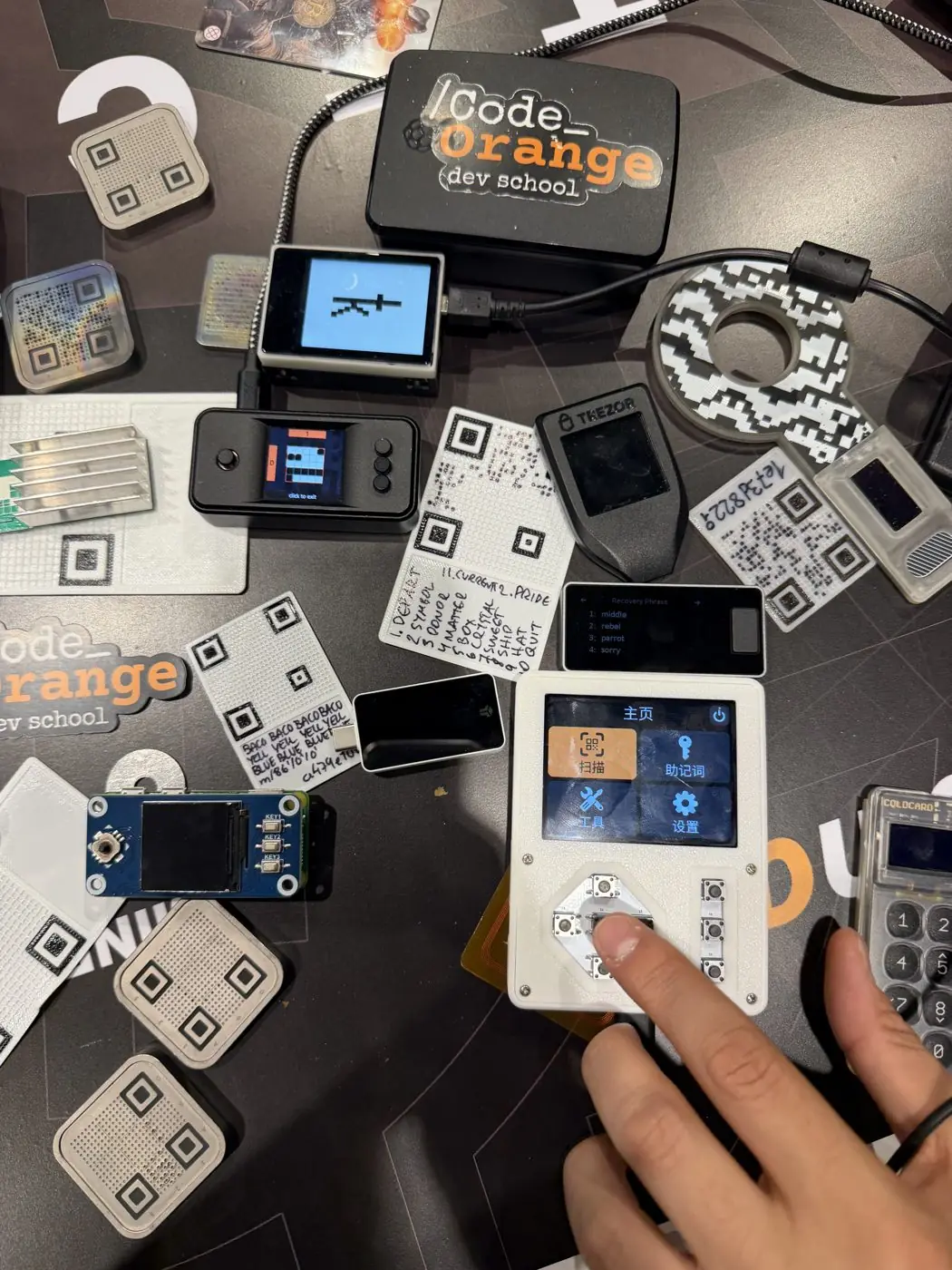 Hardware signing devices, SeedQR plates and seed word cards on a workshop table